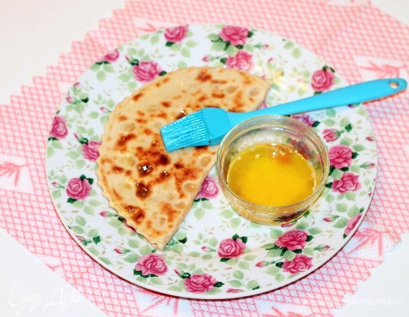 Складывая лепешки стопкой, обильно смажьте их растопленным сливочным маслом.