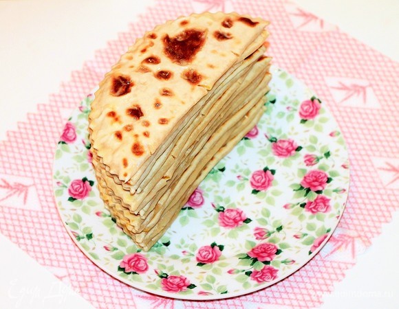 Окунули, сложили и промазали. Делаем так, пока все лепешки не закончатся. В горячую воду лепешки окунаются для того, чтобы тесто хорошо впитало масло, потому что сухое тесто, даже будучи горячим, трудно смазывается маслом, и масло чаще застывает на поверхности лепешки, и в результате оно не проникает в начинку и в само тесто.