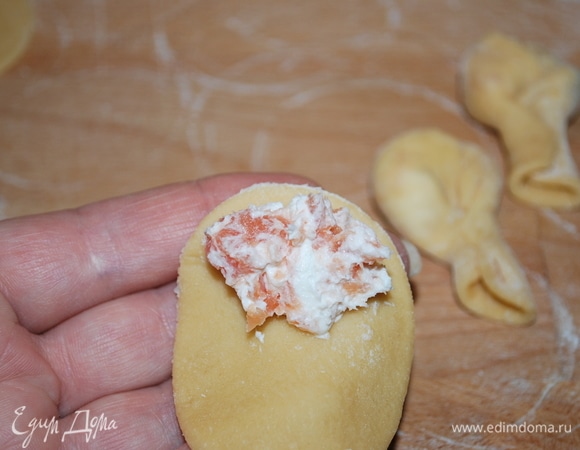 На край кружка из теста кладем начинку из сыра и рыбы.