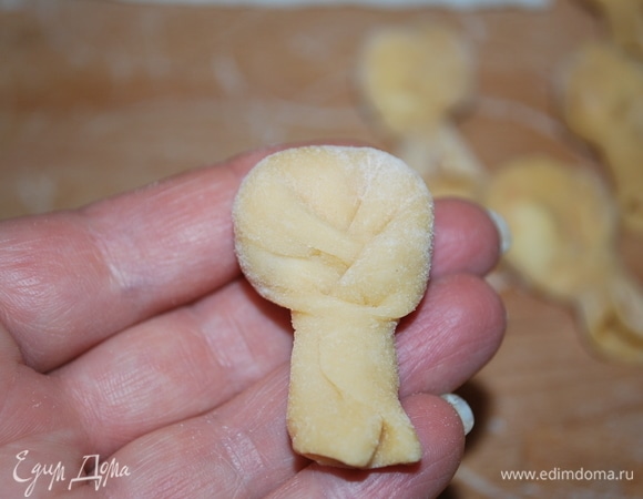 Затем попеременно сгибаем тесто то справа, то слева, чтобы получилась косичка. И конец косички придавим пальцем, чтобы начинка осталась внутри равиоли.