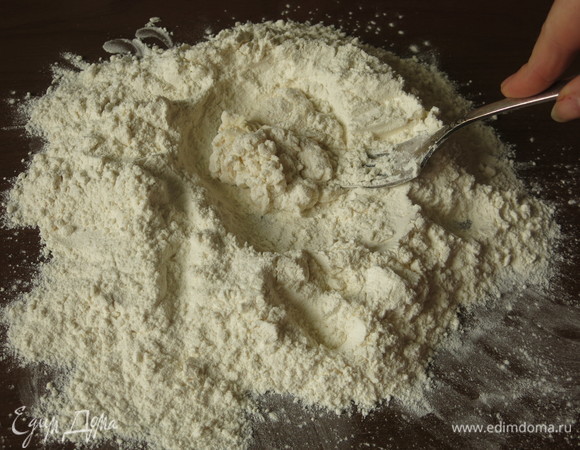 Делаем углубление и наливаем воду, замешиваем тесто вилкой.