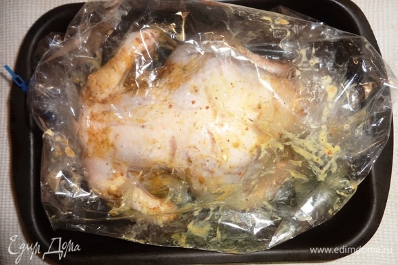 Достать курицу из холодильника. Нафаршировать дольками цитрусовых. Положить курицу в рукав для запекания. Концы рукава подвернуть и завязать. Сделать несколько проколов в верхней части рукава. Поставить курицу в духовку, разогретую до 180°C, на 30–35 минут.