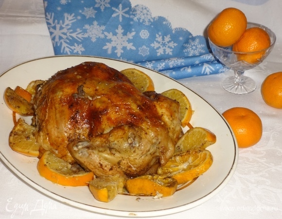 Достать из духовки форму с готовой курицей. Пока курица лежит в форме, аккуратно достать вилкой дольки цитрусовых. Выложить курицу на блюдо. Вокруг разложить мандарины и апельсины. Подать курицу на новогодний стол, дополнив гарниром по желанию. Всем приятного аппетита! С Новым годом!