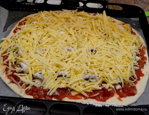 Верхний слой пиццы — это натертый сыр. У меня два вида сыра.