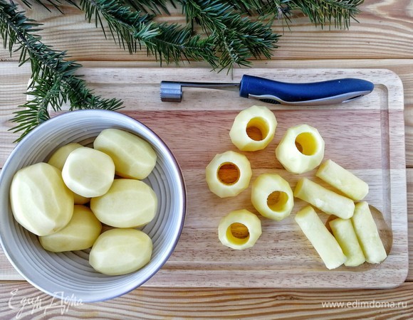 Очищенный картофель обсушить, с помощью ножа для удаления сердцевины у яблок вырезать посередине картофеля отверстия. Верх и низ картофеля нужно выровнять, если требуется. Я брала средний по размеру картофель, он быстрее приготовится.