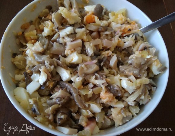 Вешенки промыть, нарезать и обжарить на сухой сковороде. Когда вода выпарится, добавить к грибам сливочное масло, мелконарезанный лук, обжарить все вместе. Добавить к начинке сваренные вкрутую яйца, тертый сыр, нарезанные остатки кальмаров. Перемешать.