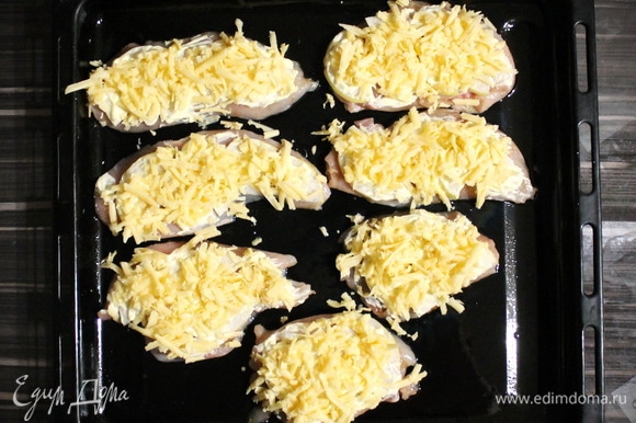 Кусочки грудки выкладываем на противень, сверху каждый кусочек покрываем слайсами груши, смазываем майонезом ТМ «Махеев» и посыпаем сыром.