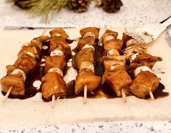 Стелим фольгу, затем — бумагу для запекания, выкладываем шашлычки, наносим сверху на рыбу маринад. Оставляем рыбу в маринаде на 10 минут.