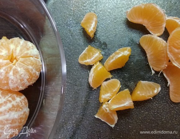 Для начинки чистим мандарины и разрезаем дольки пополам.