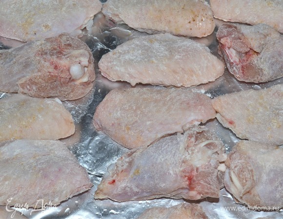 Затем застилаем противень фольгой, смазываем ее растительным маслом и выкладываем наши крылышки. Спросите, зачем мука? Потом увидите)