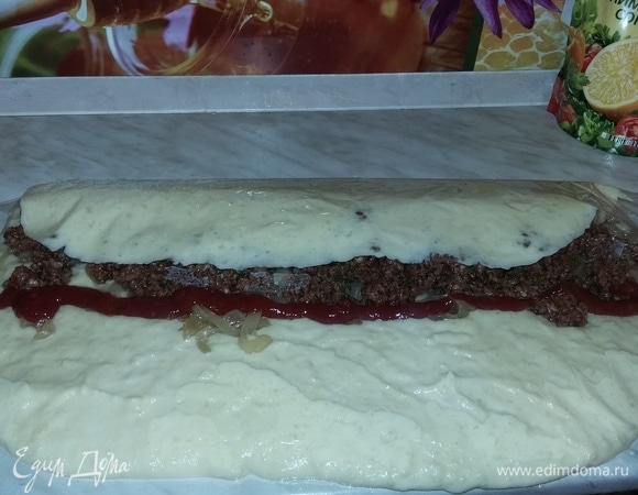 С помощью пленки сворачиваем рулет. Сначала — один край, приминаем руками; отгибаем пленку; потом — другой край. Получается, что рулет будет лежать у вас посередине отреза пленки.