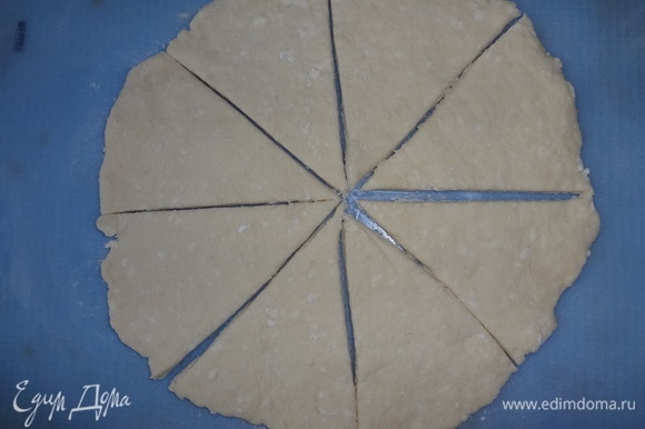 Разделить тесто на 2 части. На посыпанном мукой силиконовом коврике раскатать круг толщиной примерно 0,5 см. Разрезать круг на 8 сегментов.