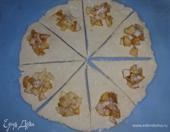 На широкий край каждого сегмента выложить немного яблочной начинки, посыпать сахаром.