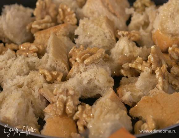 Чиабатту поломать руками на небольшие крутоны и выложить на противень, сверху посыпать грецкими орехами и полить гусиным жиром.