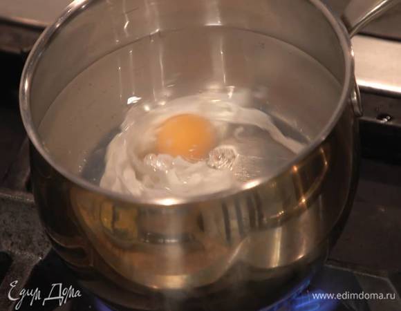 Приготовить яйца пашот: вскипятить 500 мл воды, добавить уксус, разбить одно яйцо в небольшую чашку и влить в кипящую воду, убавить огонь и варить 1–2 минуты, затем вынуть шумовкой на бумажное полотенце, а в воду отправить следующее яйцо.