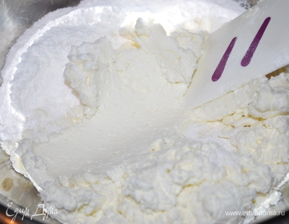 Творог протрем через сито (400 г), добавим сахарную пудру (90 г), сливки (200 г), перемешаем.