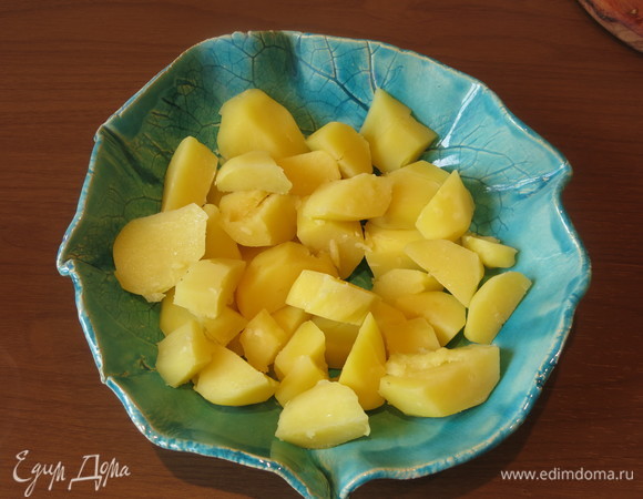 Картофель отварен, крупно нарезан и уложен в тарелку. Можно приготовить картофель и в кожуре, не нарезать, а раздавить.