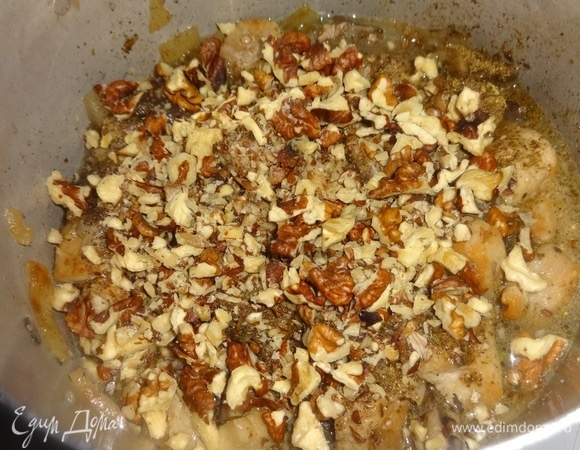 Всыпать орехи, перемешать. Налить воды, довести до кипения, убавить огонь. Накрыть кастрюлю крышкой и тушить до готовности мяса.
