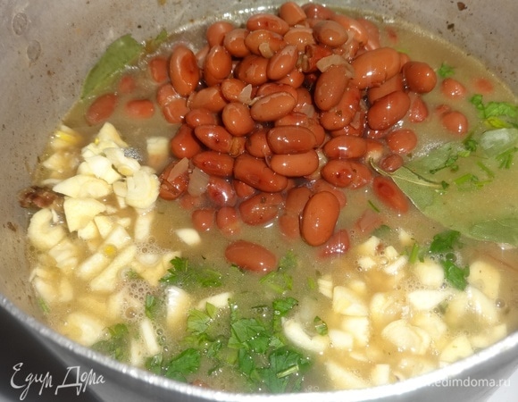 Когда мясо уже будет совсем готово, добавить в кастрюлю консервированную красную фасоль вместе с жидкостью, чеснок, зелень, лавровый лист. Попробовать на вкус. Если нужно, посолить еще. Тушить содержимое кастрюли еще 5–7 минут и выключить огонь.