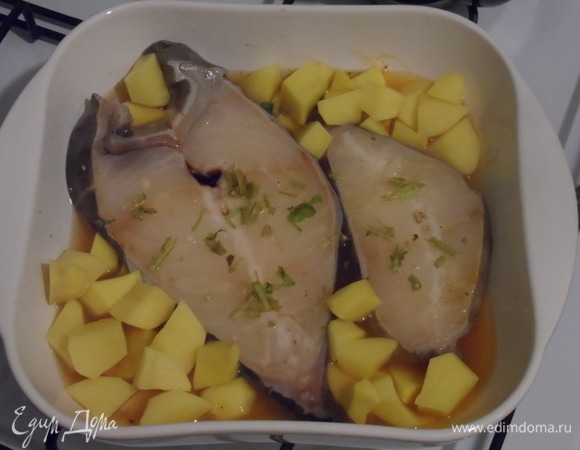 Картофель очищаем, нарезаем, добавляем к рыбе, солим немного. Также добавляем нарезанную зелень. Отправляем в предварительно разогретую до 180°C духовку на 30 минут.