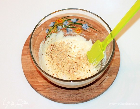 К взбитым желткам небольшими частями добавить мучную смесь, перемешать ложкой, а затем взбить венчиком. Должна получиться однородная масса без комочков. Добавить измельченные орехи, перемешать.