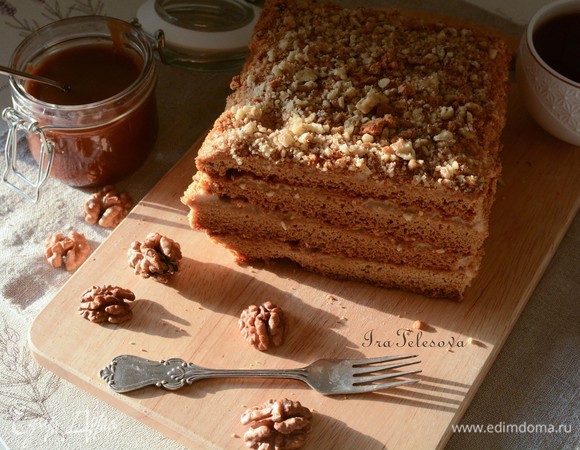 Переходим к сборке. Из одного большого коржа (разрезала на 4 части) я сделала тортик с карамельным кремом. Высота — 4 коржа. Каждый корж промазываем карамельным кремом. Обмазываем кремом верх и бока торта. Обсыпаем верх и бока крошкой из обрезков коржей. Сверху посыпаем молотыми грецкими орехами.