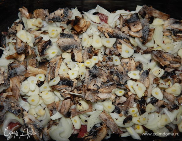 Поверх лука выкладываем нарезанные пластинками грибы и чеснок.