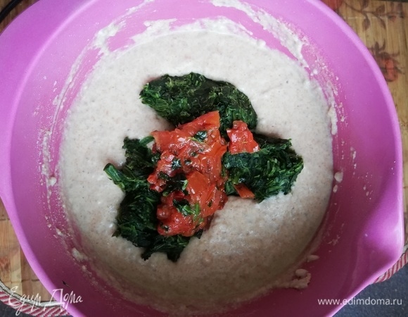 Мелко нарезать вяленые помидоры. Добавить шпинат и помидоры в полученное тесто.