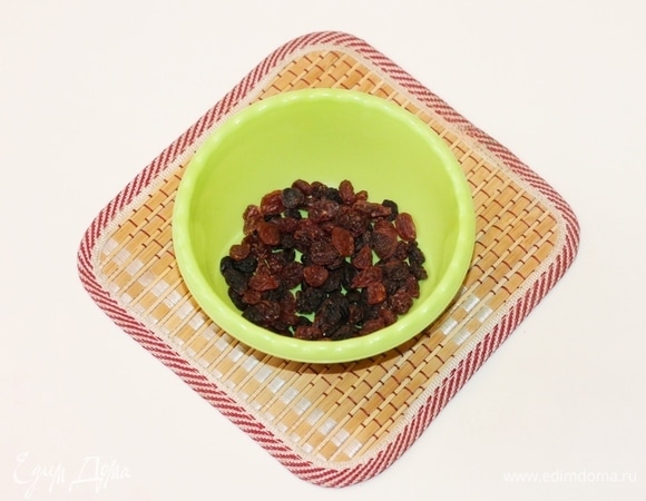 Изюм за полчаса до приготовления залить кипятком (или смесью кипятка с ромом). Воду слить, изюм выложить в сито.