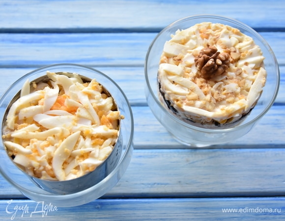 В креманку поставить сервировочное кольцо и собрать салат, чередуя слои. Каждый слой промазывать небольшим количеством майонеза. 1 слой — картофель, 2 слой — репчатый лук, 3 слой — ветчина, 4 слой — чернослив, 5 слой — грецкие орехи, 6 слой — кукуруза, 7 слой — яйца.