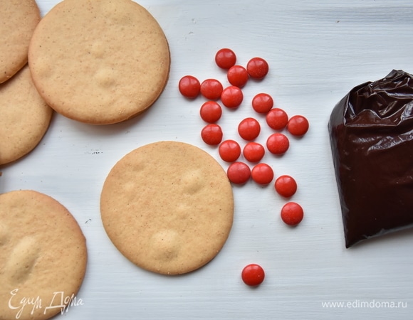 Для оформления потребуются цветные конфеты. Шоколад и сливочное масло растопить на водяной бане. Чуть остудить и переложить в полиэтиленовый пакет. Кончик пакета срезать ножницами.