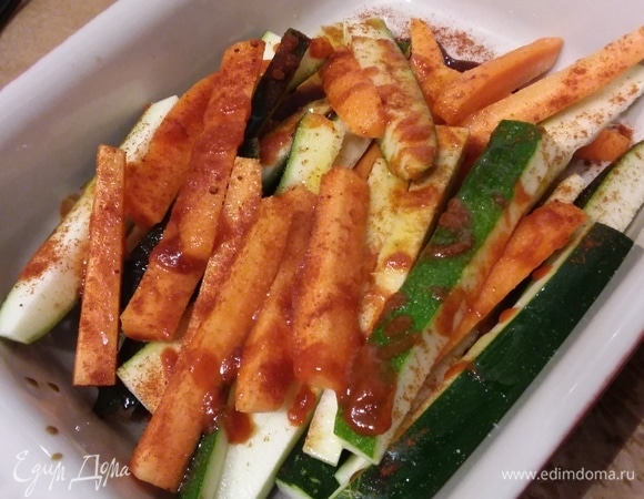 Морковь очистить и нарезать на брусочки толщиной приблизительно в палец (вдоль наполовину и каждую еще на четвертинки), также нарезать цукини. Сердцевину цукини я не стала добавлять, оставила брусочки только с кожицей. Овощи сложить в емкость, добавить соус соевый и соус шрирача, соль, перец, кленовый сироп, оливковое масло и порошок сладкой красной паприки. Все перемешать и выложить на одну половину противня, покрытого пергаментной бумагой. Отправить в заранее разогретую до 200°C духовку на 12–15 минут. Если такого соуса нет, его можно заменить на другой острый соус чили, а кленовый сироп из шага 1 — на мед или сахар.