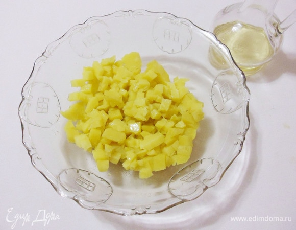 Переложить картофель в салатник, полить оставшимся оливковым маслом и белым винным уксусом.