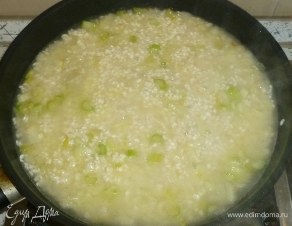 Влить вино, перемешивать, пока оно не выпарится. Добавлять бульон небольшими порциями. Готовить, помешивая, до впитывания бульона. Повторять процедуру почти до готовности риса. Приправить солью и перцем.