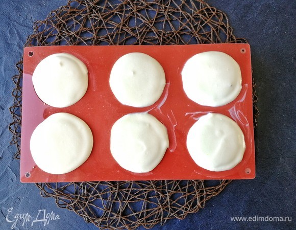 Сверху заливаем нежным муссом. Видите, мусс выходит из формочек, находится над ними шапочкой, но никуда не растекается, настолько он воздушный, но при этом полностью стабильный! Ставим десерт в морозильную камеру на сутки. Неровности по краям, которые вы видите, я убрала, когда мусс подмерз (буквально через 2 часа): я просто нагрела чайную ложку и ей выровняла края пирожных.