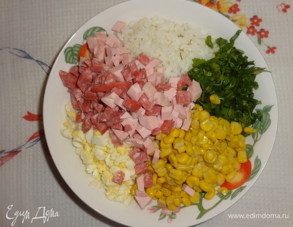 В глубокой миске соединить рис, кукурузу, колбасу, яйца, зелень, перемешать.