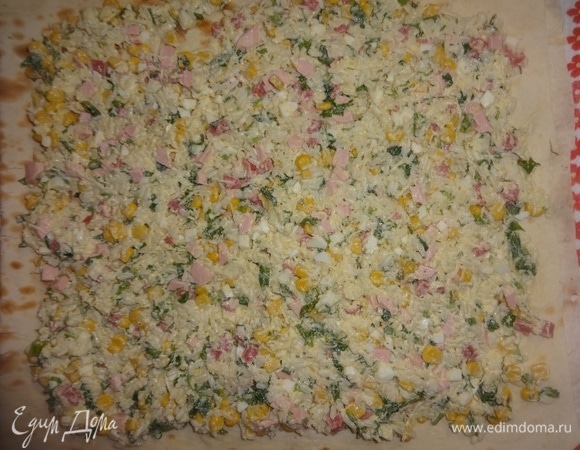 На внешнюю поверхность лаваша выложить начинку по периметру, не доходя до одного из горизонтальных краев 8–10 см, а до вертикальных — 2–3 см.