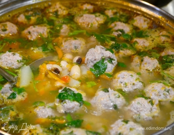 Когда фасоль практически готова, добавляем постепенно картошку, затем — овощи и фрикадельки, специи, травы. Доводим до готовности суп, добавляем свежую зелень, и суп готов!