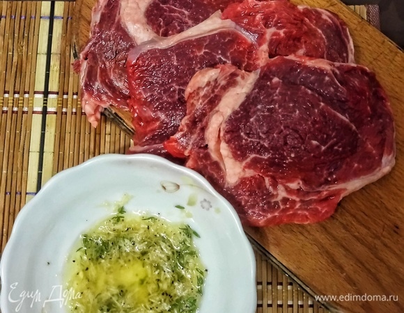 Ставим разогреваться сухую сковороду на сильный огонь, одновременно ставим разогреваться духовку до 200°C. А тем временем готовим заправку: чеснок натрем на мелкой терке, измельчим веточки тимьяна, все смешаем с оливковым маслом, солью и перцем. Кладем мясо на раскаленную сухую сковороду, сверху смазываем нашей заправкой, уменьшаем огонь до уровня чуть выше среднего, жарим 2 минуты и переворачиваем.