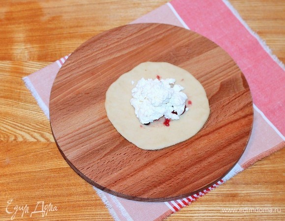 Кладем творожную массу и формируем круглый пирожок. Переворачиваем пирожок, немного подпыляем шов и выкладываем в форму для выпечки диаметром 26 см.