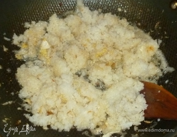 В сковороду налить соевый соус и выложить рис. Жарить пару минут, помешивая.