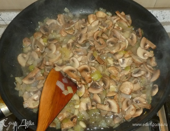 Шампиньоны нарезать тонкими ломтиками, выложить в сковороду. Жарить до испарения жидкости.