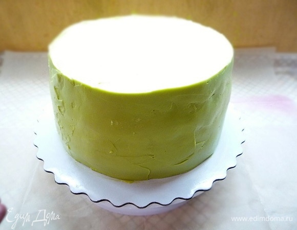 Приготовим крем для украшения. В чашке взбиваем сливочное масло с сахаром до пышной светлой массы, добавляем творожный сыр, ванилин, еще раз взбиваем, добавляем фисташковую пасту, перемешиваем и наносим на торт ровным слоем.
