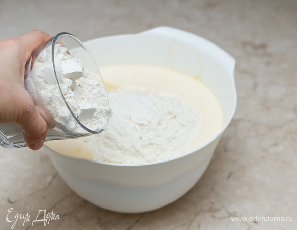 Добавьте муку, смешанную с содой и разрыхлителем для теста. Тщательно перемешайте тесто, чтобы не было комков.
