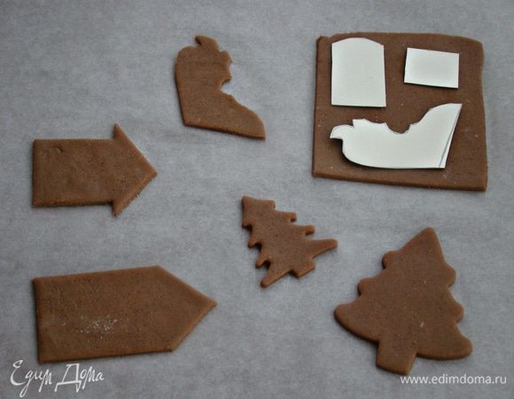 Теперь займемся декором для торта. Для этого испечь из имбирно-медового теста детальки саней, домики и елочки. Остывшие заготовки раскрасить сахарной глазурью. Рецепт пряничного теста находится здесь — https://www.edimdoma.ru/retsepty/110420-tort-yaschik-s-apelsinami.