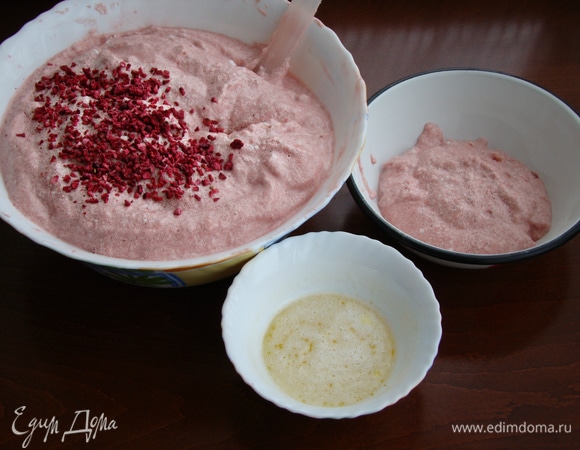 Часть теста отложить в отдельную миску. Сливочное масло растопить и остудив до комнатной температуры, влить в тесто. Тщательно перемешав, влить к основной части теста. Добавить пару столовых ложек сублимированной малины и все перемешать. Готовое тесто перелить в форму (18 см) застеленную пекарской бумагой. Выпекать в разогретой до 170–180°C духовке минут 25–30, до сухой лучинки. Готовый бисквит остудить на решетке и завернув в пленку, положить в холодильник на несколько часов.