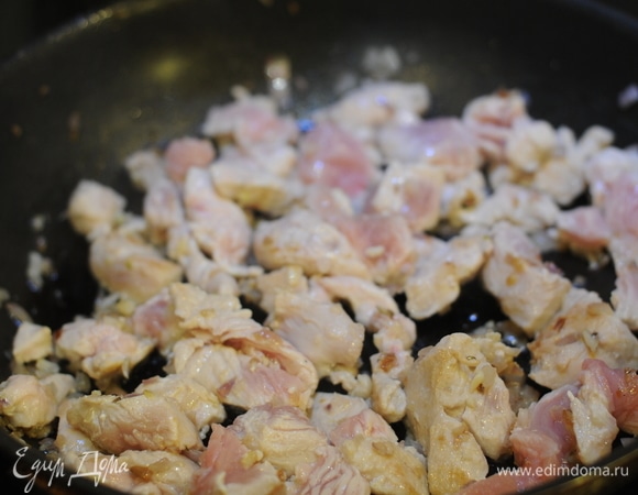 В ту же сковороду добавляем ложку масла, высыпаем оставшийся лук. Через 3 минуты добавляем чеснок. Затем индейку. Через 5 минут вливаем белое вино и тушим еще 5 минут.
