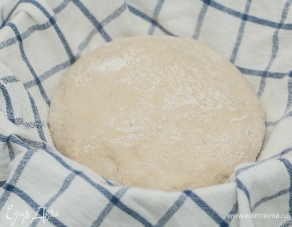 Через 20 минут разделить тесто на 2 части, сформовать хлеб и оставить еще на 1,5–2 часа в теплом месте для подъема. Этот процесс называется расстойка. Расстойку часто проводят в специальных корзиночках, но вместо них подойдут любые миски или дуршлаг, в которые надо постелить натертое мукой х/б или льняное полотенце.