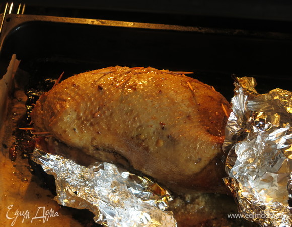 Снимаем фольгу, закрываем лапки и хвостик кусочками фольги, уменьшаем нагрев до 180–160°C прожариваем еще час, периодически поливаем маринадом.