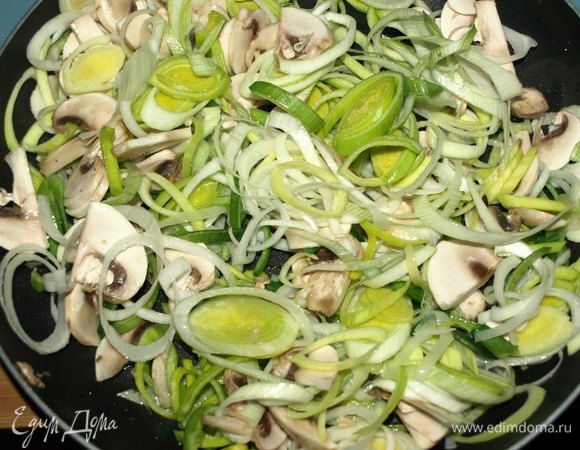 Приготовим начинку. Лук порей промыть, обсушить и нарезать кольцами (белую часть). Грибы нарезать пластинами. В глубокой сковороде разогреть растительное масло, добавить лук-порей и грибы. Готовить 2–3 минуты.